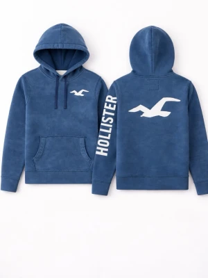   Hollister Hoodie - Snygg blå hoodie från Hollister med vit logga på bröstet och stor logga på ryggen. Hoodien har en klassisk känguruficka, dragsko i huvan och tryckt text på ena ärmen. Perfekt för en avslappnad och trendig stil.