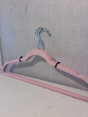 3st rosa sammetsgalgar - Säljer tre stilrena galgar i ljusrosa sammet med metallkrok. Galgarna har en klassisk form. Perfekta för att hänga upp tröjor, jackor eller klänningar i garderoben.