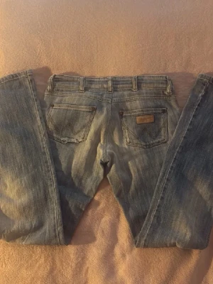 Wrangler lågmidjade bootcut jeans vintage - Så så coola & snygga vintage ljusblå lågmidjade bootcut jeans från Wrangler!! Liten slitning på bakfickan som man ser på bilden. W27/L32