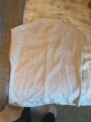 Beige ribbad väst från Gina Tricot - Snygg beige väst från Gina Tricot i ribbat material. Västen är ärmlös och har en enkel, rak passform som funkar till många olika outfits. Perfekt att slänga över en skjorta eller t-shirt för en trendig lager-på-lager-look.
