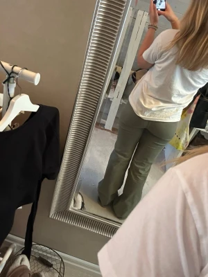 Olivgröna bootcut jeans - Säljer ett par olivgröna jeans med bootcut passform och markerade sömmar framtill. Dem är från HM och är helt slutsålda! Supersnygga till vår och sommar! 