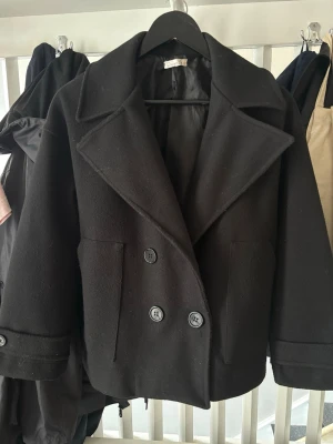 Svart kappa från DesignBySi - Svart kappa från DesignBySi. I jätte fint skick, nästan helt oanvänd. Köpt för 800kr. 