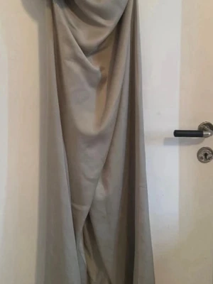 Mintgrön omlottklänning med slits - Elegant mintgrön  långklänning i omlottmodell med slits framtill. Klänningen har en draperad överdel och är ärmlös, vilket ger en stilren och modern look. 
