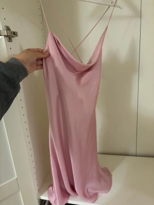 Rosa sidenklänning från Zara - Supersnygg rosa miniklänning i sidenlook med tunna axelband och djup rygg. Framsidan är lite asymmetrisk. 