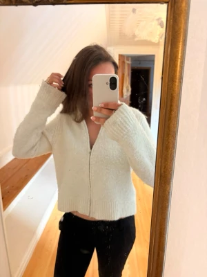 Stickad ziptröja  - Mysig stickad tröja med långa ärmar. Tröjan är fluffig och har ribbade muddar vid ärmslut och nederkant. Perfekt för en avslappnad och chill stil. Passar bra till både jeans och mjukisbyxor.
