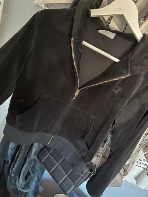 Svart velour hoodie från Juicy Couture - Säljer en svart velour hoodie från Juicy Couture med guldfärgad dragkedja som dock tappat lite färg 