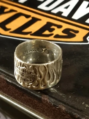 Harley-Davidson Flames- RARE MOD Vintage Silver 925 flame Ring. US8 - Kopierade min ebay annons.  Up for sale is a genuine, collector-grade Vintage Harley-Davidson Flame Band. This is a heavy-weight, wide-band "open-cut" flame design crafted by MOD Jewelry, the premier official licensee for Harley-Davidson’s high-end sterling silver collections.  Unlike modern mass-produced stainless steel versions, this ring is solid .925 Sterling Silver with a deep, natural patina that makes the flame detail pop. This specific design is retired and increasingly difficult to find
