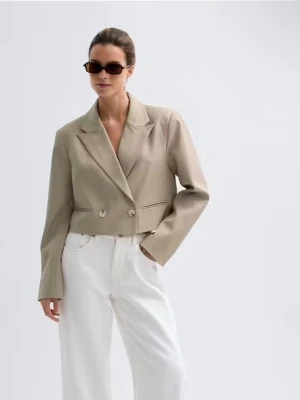 Beige cropped kavaj med dubbelknäppning - Stilren beige cropped kavaj med dubbelknäppning framtill och breda slag. Kavajen har raka axlar, långa ärmar och två dekorativa fickor. Tillverkad i ett slätt tyg som ger en modern och clean look. Perfekt för dig som gillar trendiga och minimalistiska plagg.