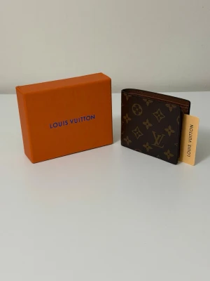 L.V plånbok - Stilren design med fokus på både funktion och elegans. Ett perfekt val för dig som vill kombinera praktisk förvaring med en sofistikerad känsla. 