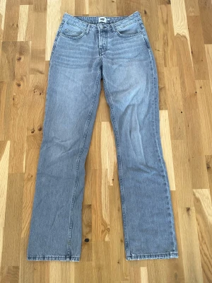 Ljusgrå raka jeans - Ljusgrå jeans med rak passform och klassisk femficksdesign. Jeansen har normal midja och är tillverkade i denim med subtil tvätt för en avslappnad look. Perfekta för dig som gillar en enkel och tidlös stil.