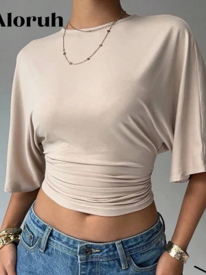 Beige croppad topp  - Trendig beige croppad topp från Aloruh med lös passform upptill och åtsittande midja. Toppen har korta, vida ärmar och ett snyggt rynkat parti vid midjan som ger en cool siluett. Perfekt till jeans eller kjol för en avslappnad men stylish look.