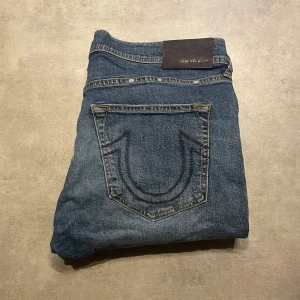 True Religion Jeans - Tja! Säljer dessa schyssta TR jeansen till ett bra pris! Storlek 32 passar bra på 185 ca! Regular / slim fit. Riktigt schysst tvätt på de. Vid frågor är det bara att höra av sig ! Den har just nu några så fläckar men de går bort i tvätten. Allt gott!