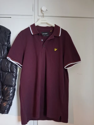 Vinröd pikétröja från Lyle & Scott - Supersnygg vinröd lyle&scott piké köpt för 600 på MQ. ÄKTA (Utan kvitto tyvärr) har screenshot på artikelnumret som matchar lappen i tröjan. Precis som den marinblåa är denna nytt skick och bara testad/använd hemma. Pruta gärna ner den om priset känns för högt!