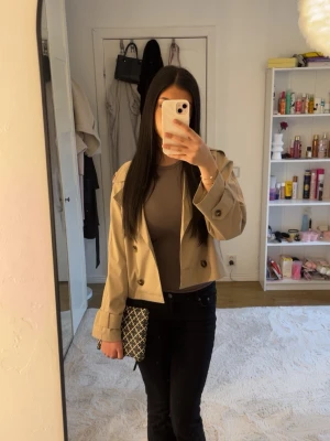 Begie trenchcoat  - Fin enkelt trenchcoat utan band. Endast använd en gång och det är på bilden. Är i storlek 158/164 men passar perfekt på mig som bär storlek Xs-S