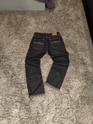 Nudie Dry Jeans Vintage - Säljer ett par dry Nudie jeans i modellen Easy Emil. Storleken är W31 L32. Färgen heter DRY DARK. Jeanslappen på bild 7 följer också med vid sidan av om önskas.  Hör av dig vid frågor!