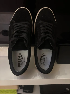 Svarta mockasneakers från vagabond - Snygga svarta sneakers från vagabond med ovandel i mocka och klassisk vit sula. Skorna har svart snörning och en stilren, minimalistisk design som passar till det mesta. Perfekta för dig som gillar en clean look.