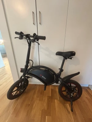Dyu D3F Elscooter/Elcykel - DYU D3F 250W elcykel – smidig & kompakt ⚡🚲  Säljer en stilren och praktisk DYU D3F elcykel, perfekt för pendling i stan eller kortare turer. Den kompakta designen gör den enkel att förvara och ta med.  • Toppfart: 20 km/h  • Integrerat batteri i ramen  • Kraftiga skivbromsar fram och bak  • Bekväm sadel och stabila, breda däck Cykeln är i mycket fint skick och fungerar felfritt – bara att sätta sig och köra 👍  För fler bilder hör av dig📸 Laddare följer med. Annons kvar= cykel kvar 📍Halmstad