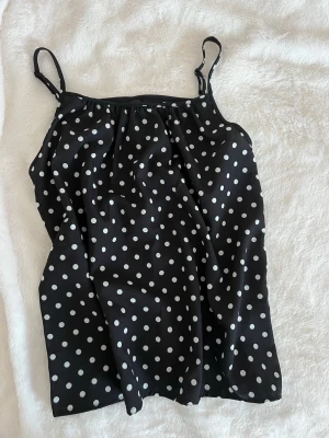 Svart prickig topp - Svart topp med vita prickar och tunna axelband. Från shein