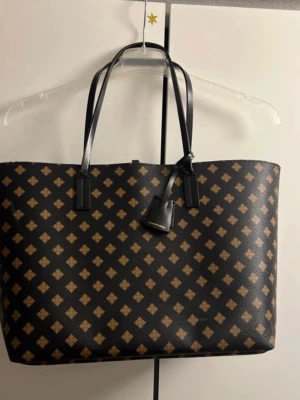 Brun svart väska By Malene Birger  - Perfekt för dig som vill ha plats för allt du behöver under dagen. -Den har lite slitsamma märken på såsom man ser på bilderna & hörnen  - Lite märken i själva väskan men det ska nog lätt fixas om man rengör den.  -Hade rekommenderat å ta den till ens skräddare för remarna och dem eventuella märken , annars är den fortfarande snygg och hållbar.  - Dragkedjan i innerfickan funkar inte heller som den ska men inget som har stört min vardag. Väskan kan absolut fortfarande användas till skolan osv. 