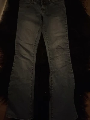 Blå bootcut jeans med paljetter - Säljer ett par blå bootcut jeans med snygga paljett detalj på bakfickan. Jeansen kommer i bra skick eftersom de är knappt använda eftersom de är försmå för mig, jag har storlek 34-36 vilket gör de en 32 ungefär, jätte low waist. Köpt på vintage butik i England för samma pris💕