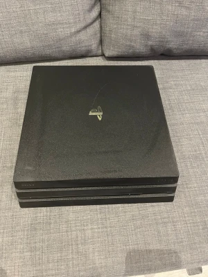 PlayStation 4 Pro svart konsol - Säljer en svart PlayStation 4 Pro 1 tb från Sony. Konsolen har en stilren, fyrkantig design med tre lager och PlayStation-loggan i silver på ovansidan. Tillverkad i matt plast och passar perfekt för gaming och streaming. Orginal Kablar samt spel kontroll även.