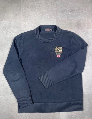 Mörkblå stickad tröja från Morris - Säljer en grovstickad Morris-tröja i snygg märkblå färg.  Märke: Morris  Storlek: L men passar även Medium  Färg: Märkblå / navy  Design: Grovstickad tröja  Skick: Mycket bra, se bilder!  Beskrivning:  Klassisk design från Morris  Grovstickad kvalitet - varm och bekväm  Perfekt för vardag, höst och vinter  Ribbstickade muddar och kant för bra  passform  Inga fläckar, noppor eller skador (kontrollera bilder)  Lätt att matcha med jeans, chinos eller lager- på-lager  Har du några frågor är det bara