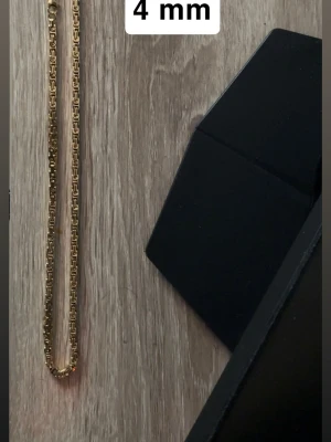 Guldpläterat halsband 58 cm - Snyggt Guldpläterat halsband med. Halsbandet är 4 mm brett och har en stilren, modern design som passar perfekt till olika looks. Materialet ser ut att vara metall med guldfinish.