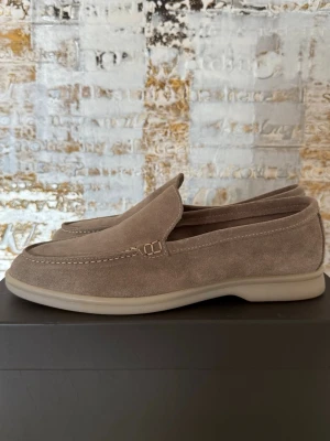Beige mocka loafers från Spada Roma - Snygga loafers i beige mocka från Spada Roma med storlek 43.Skorna har en klassisk slip-on design med diskreta sömmar och en mjuk, flexibel sula i gummi. 