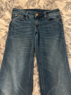  Korta Ljusblå jeans från Cheap Monday - Säljer ett par ljusblå jeans från Cheap Monday med bootcut och klassisk femficksmodell. Jeansen har en snygg tvätt och ett stort vitt Cheap Monday-märke bak i midjan. Perfekta för en avslappnad och trendig look.