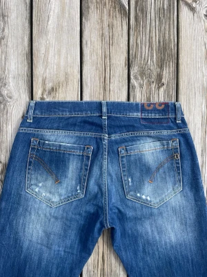 Mörkblåa Dondup George jeans med slitningar  - Mörkblåa Dondup George jeans som är i nyskick med otroligt feta slitningar. Storleken är W32 och modellen heter George. Hör gärna av er vid intresse!