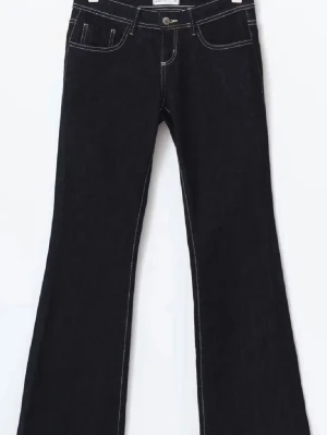 Mörkblåa low waist jeans - Gina Tricot - Snygga mörkblåa lowwaist jeans med vita kontrastsömmar och klassisk femficksmodell. Jeansen har låg midja och utsvängda ben. Jeansen är i helhet i väldigt bra skick och pris kan diskuteras!