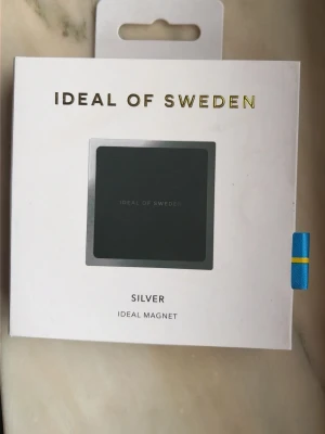 Ideal of Sweden magnet silver - Snygg  magnet från Ideal of Sweden i silverfärg. Perfekt för att fästa mobilen på olika ytor, till exempel i bilen på skrivbordet eller på spegeln! Kompatibel med alla telefonmodeller! Helt i nyskick! 