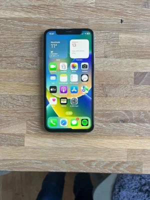 iPhone X silver  - Säljer en stilren iPhone X i silver med 64GB lagring. Telefonen har en snygg glasbaksida, rundade hörn och en stor OLED-skärm med Face ID. Klassisk Apple-design med metallram och dubbla kameror på baksidan. Perfekt för dig som gillar smidig och modern mobil.