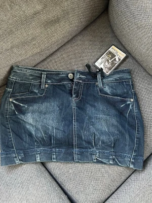 Blå jeanskjol från Sublevel - Snygg blå jeanskjol från Sublevel med slitna detaljer och klassisk femficksdesign. Aldrig använd med prislappen kvar💕Midjemått över höften: 48 cm💕