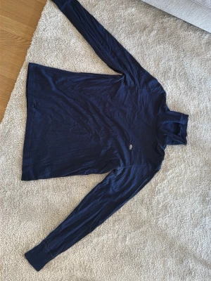 Mörkblå polotröja från Lacoste - Snygg mörkblå polotröja från Lacoste med klassisk krokodillogga på bröstet. Tröjan har lång ärm och är tillverkad i mjukt bomullsmaterial. Perfekt för dig som gillar stilrena och tidlösa plagg. Pris kan diskuteras 