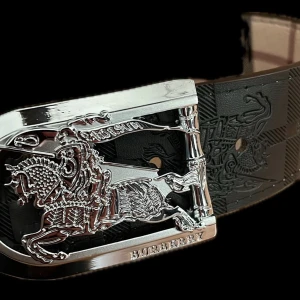 Burberry rutigt bälte med silverdetaljer - Snyggt bälte från Burberry med klassiskt rutigt mönster i beige, svart och rött. Bältet har en exklusiv silverfärgad spänne med Burberrys ikoniska riddare. Perfekt accessoar för att lyfta din outfit.