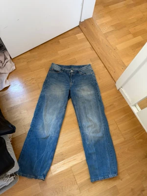 Blå jeans med slitningar - Säljer ett par blå jeans med raka ben. Slitna längst ner. Från weekday i modellen ample. S/M