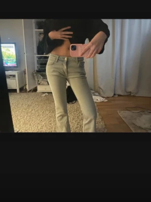 Ljusblå bootcut jeans - Säljer ett par ljusblå bootcut jeans med klassisk femficksdesign och normalhög midja. Jeansen har en snygg passform som framhäver benen och är perfekta till en avslappnad look. Materialet är denim i bomull. Inga synliga slitningar eller detaljer från något specifikt märke.