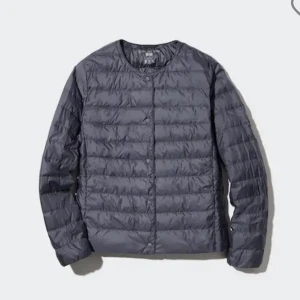 Mörkgrå dunjacka från Uniqlo - Säljer en stilren mörkgrå dunjacka från Uniqlo med rund hals och knappar framtill. Jackan är lätt, quiltad och har en clean look utan krage. Perfekt att slänga på sig när det är kyligt ute. Bilden är lånad men min är bara använd en gång och ser som ny ut. Skriv om fler bilder önskas