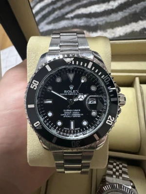 Rollie svart och grönt - Säljer en klassisk Submariner med svart urtavla och silverfärgad länk i metall. Klockan har tydliga vita markeringar, datumfönster med förstoringsglas och vridbar svart bezel. Perfekt för dig som gillar stilrena och exklusiva accessoarer. Finns 2 klockor tillgängliga, svart och grön… 1x 764kr   2x 1 527kr Kolla på andra annonsen som har FRI FRAKT