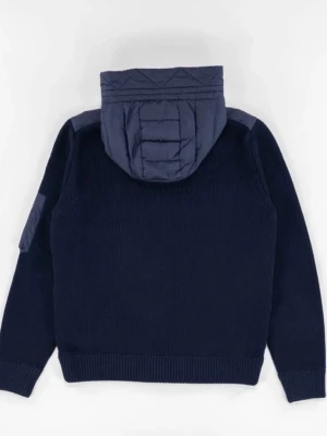 Mörkblå pufferjacka från Moncler - Snygg mörkblå pufferjacka från Moncler med stickade ärmar och quiltad framsida. Jackan har huva, dragkedja och två fickor framtill. Perfekt för kyliga dagar och ger en sportig men stilren look. Den har också scann vid moncler loggan. 