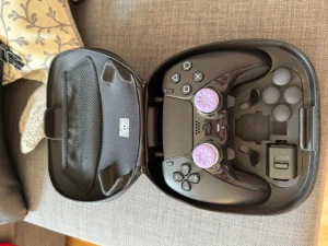 Sony DualSense Edge PS5 handkontroll - Säljer en svart Sony DualSense Edge handkontroll till PS5. Kommer i original hårt fodral med extra tillbehör och utbytbara spakar. Kontrollen har lila tumgrepp med mönster och ergonomisk design för bästa spelupplevelse.