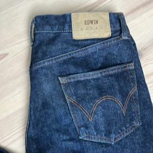 Japanese Selvedge Edwin jeans   - Snygga mörkblå jeans från Edwin med klassisk femficksdesign och selvedge-detalj i benslutet. Jeansen har raka ben och kontrastsömmar, tillverkade i robust denim. Perfekta för dig som gillar japansk denim och stilrena detaljer. Storlek : 29 x 30, nästan oanvända!