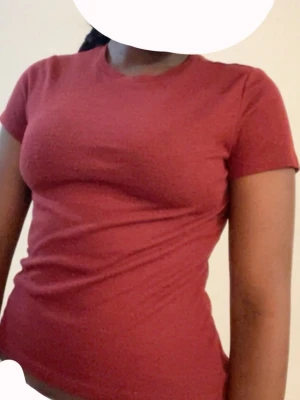 VinRöd tight t-shirt i bomull - En enkel och stilren vinröd t-shirt med rund hals och korta ärmar. Modellen är tight och passar perfekt till jeans eller kjol. Tillverkad i mjuk bomull för en bekväm känsla hela dagen.