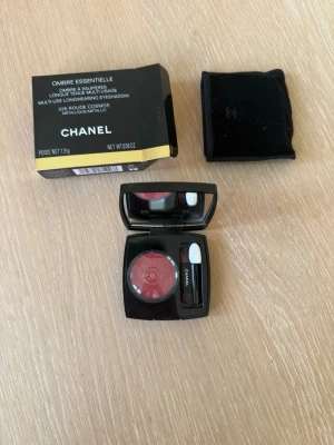 Chanel röd metallic ögonskugga - Lyxig ögonskugga från Chanel i nyansen Rouge Cosmos. Färgen är en skimrande röd med metallicfinish. Kommer i en elegant svart dosa med spegel och applikator samt originalförpackning och sammetsfodral. Helt oanvänt.