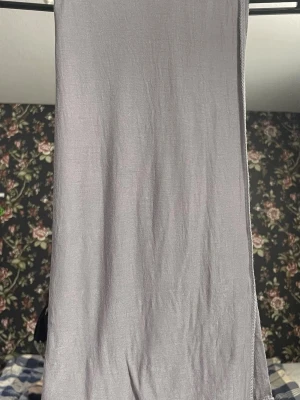 Jersey Hijab - Säljer en jersey hijab i vacker silver/ljusgrå färg. Materialet är super mjukt, stretchigt och skönt. Endast använts ett fåtal gånger (som ny), behöver bara strykas. Slöjan har två olika sidor, en som är silvrig och lite skimrande, och den andra är en matt ljusgrå.   Längd: ca 170 cm Bredd: ca 80 cm