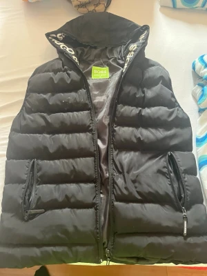 HUGO BOSS VÄST - Bra för sommaren. Hugo boss loggan är av. Går inte och knäppa upp. (Därför billigt). Scan funkar. Går in i Hugo boss hemsidan.