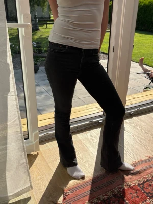 Svarta bootcut jeans med hög midja - Hög midja och klassisk femficksdesign. Materialet känns mjukt och stretchigt för extra komfort.
