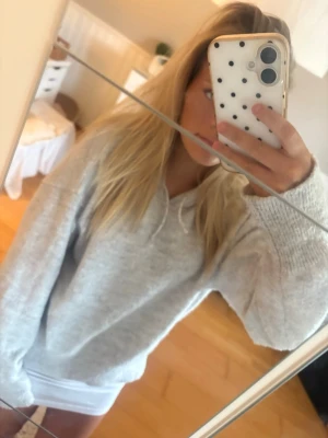 Ljusgrå hoodie med huva - Mysig ljusgrå hoodie med huva och dragsnören. Tillverkad i mjukt material som känns skönt mot huden. Klassisk passform med ribbade muddar vid ärmslut och nederkant. Perfekt för chill dagar eller när du vill ha en enkel och stilren look. Storlek 170