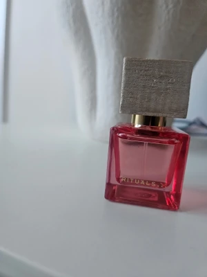 Rituals Rêve de Hanami parfym 15 ml - Säljer en Rêve de Hanami eau de parfum från Rituals. Flaskan är fyrkantig i rosa glas med en elegant träfärgad kork och gulddetaljer. Doften är exklusiv och flaskan har en modern design som sticker ut på parfymhyllan.